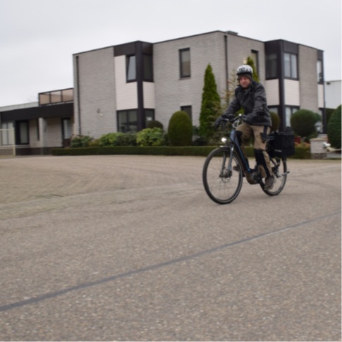 Een man fietst over straat met een elektrische fiets